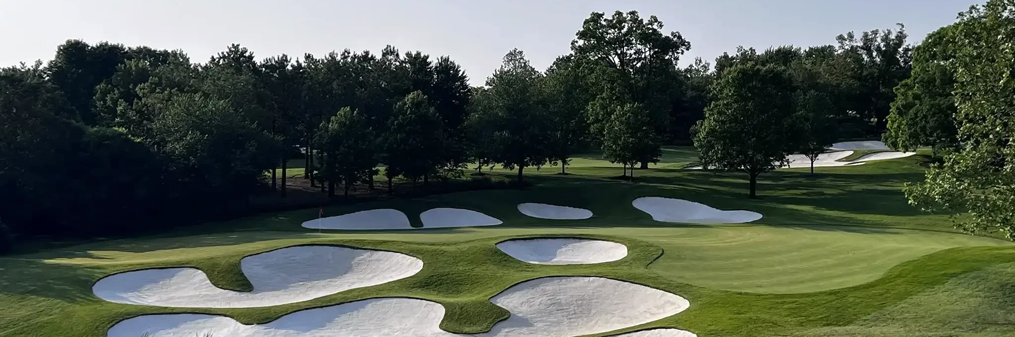 Overlook of beautiful green golf course with stark white sand bunkers