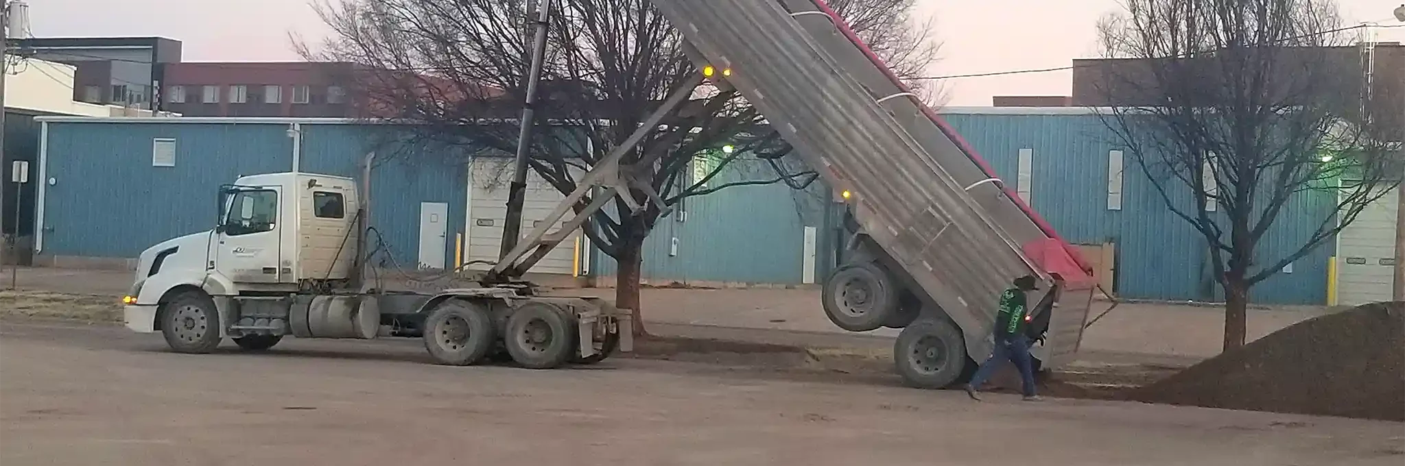 Infield clay being unloaded from a large truck.