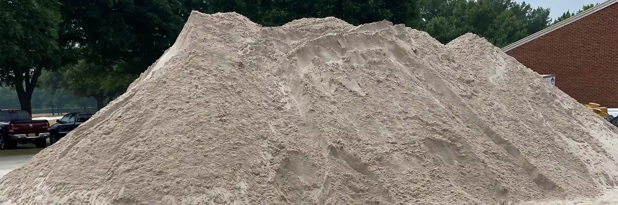 A large pile of topdressing sand stored outside.